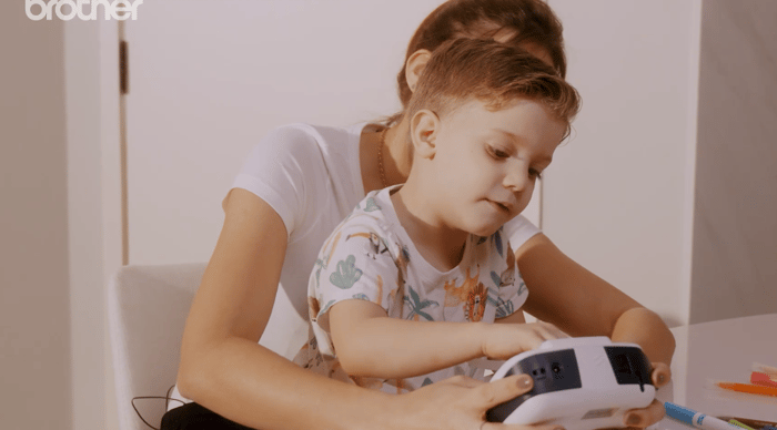 Criança rotulando material escolar